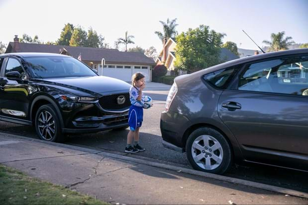 Young girl looking at a car in an accident