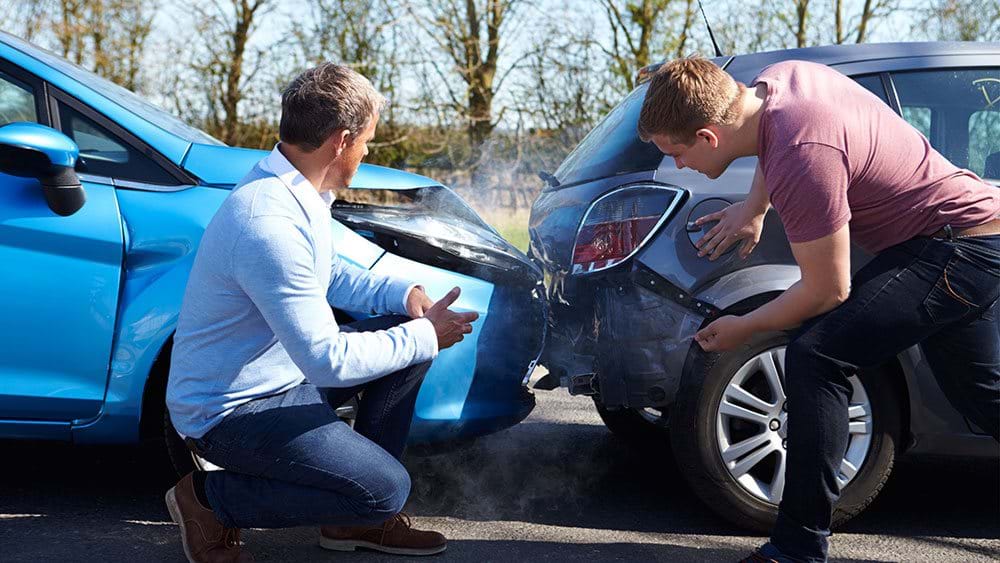 Image of two men looking at a dangerous car crash